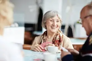 Woman in her 80's with Schizophrenia playing cards with her friends