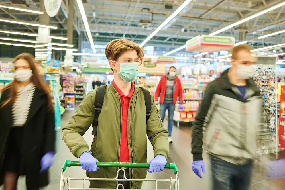 man in mask and gloves with paranoia at the grocery store