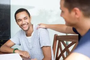 A young man consoling his friend to show his support and empathy.