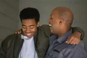 A father supporting his son and teaching him how to handle adult responsibilities.