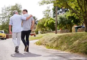 Father with adult son walking down a path discussing the future and how they can support one another.