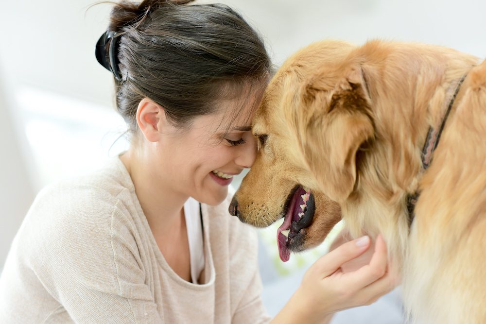 woman taking a mental health break and boosting her serotonin by petting her dog