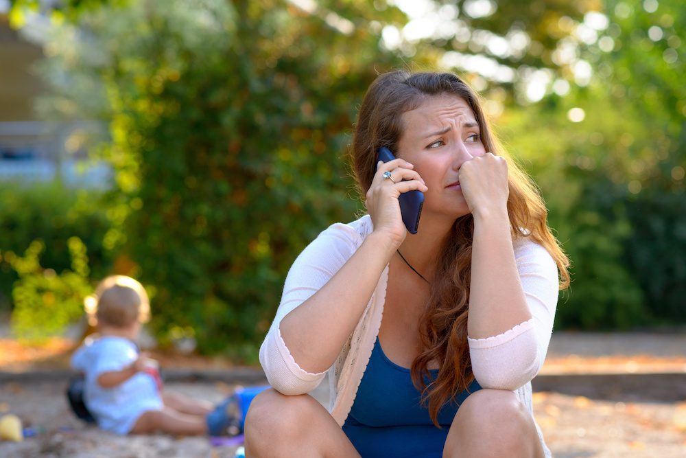 woman with bipolar disorder calling husband in the park while having a bipolar episode