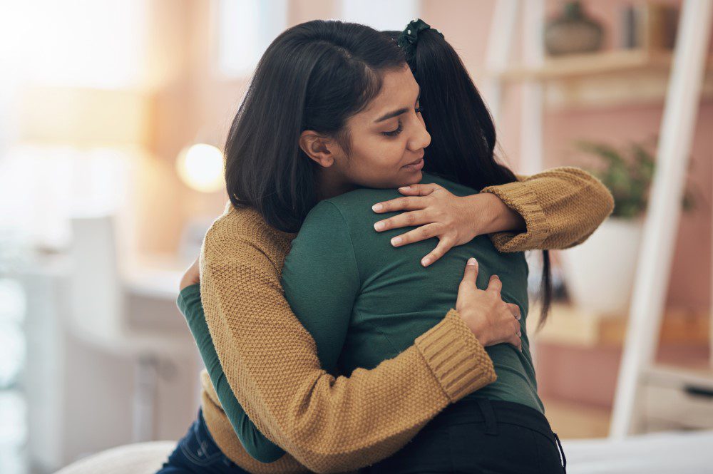 A woman hugging her sister to show she supports her through her mental health struggles.
