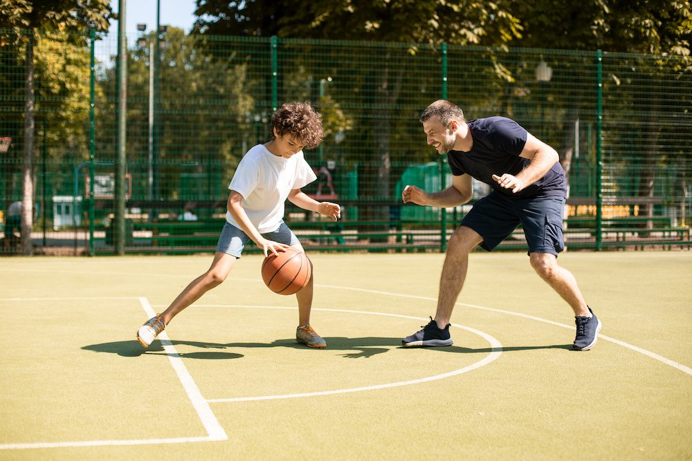 father playing basketball with his child after successful assertive community treatment