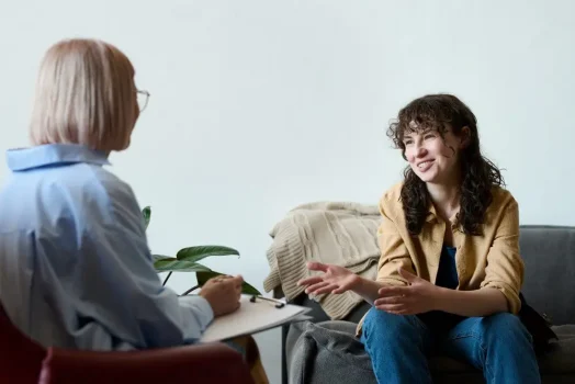 A woman speaking to her psychiatrist about her goals throughout cognitive behavioral therapy.
